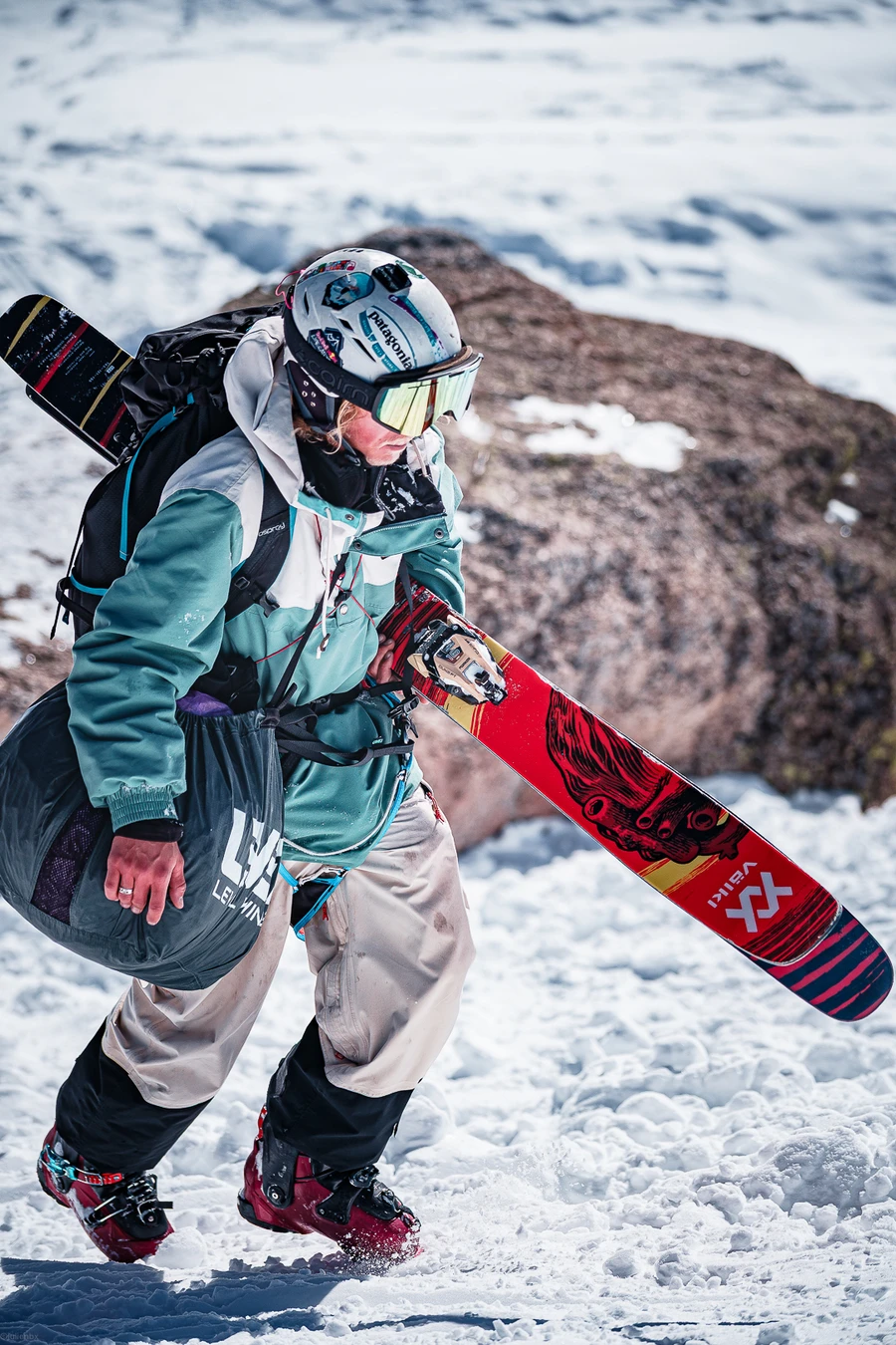 Pilote équipé pour le speedriding, skis à l’épaule
